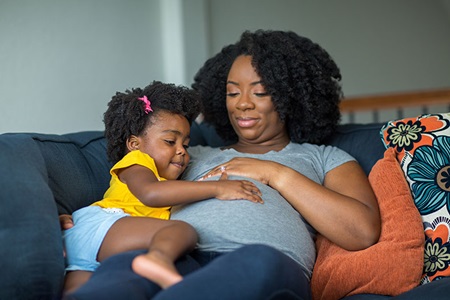 African American pregnant mother with her daughter